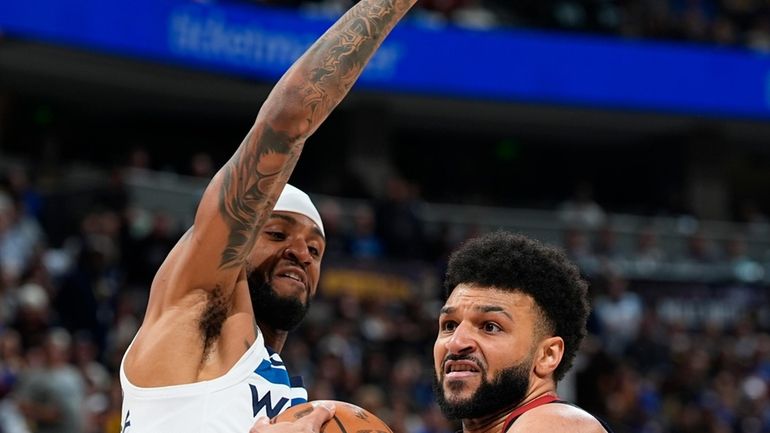 Denver Nuggets guard Jamal Murray, right, drives to the basket...