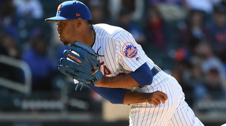 Mets relief pitcher Edwin Diaz follows through on his pitch...