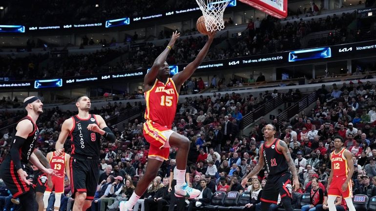 Atlanta Hawks center Clint Capela, right, drives to the basket...