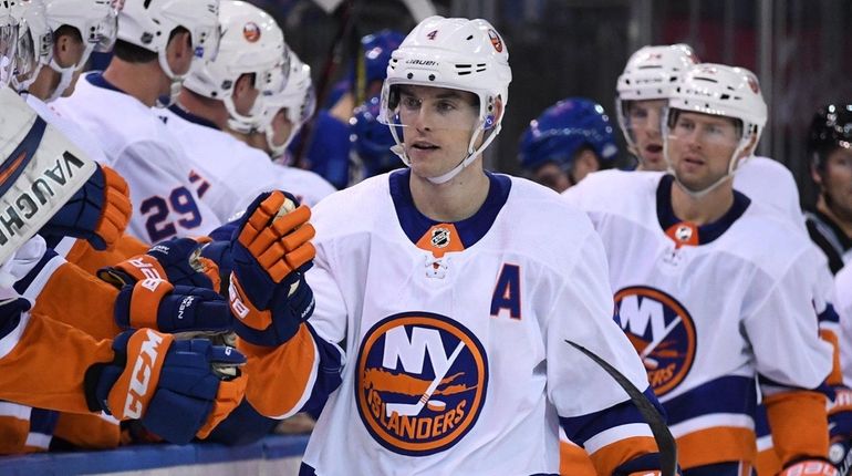 Islanders players congratulate defenseman Thomas Hickey after he scores against...