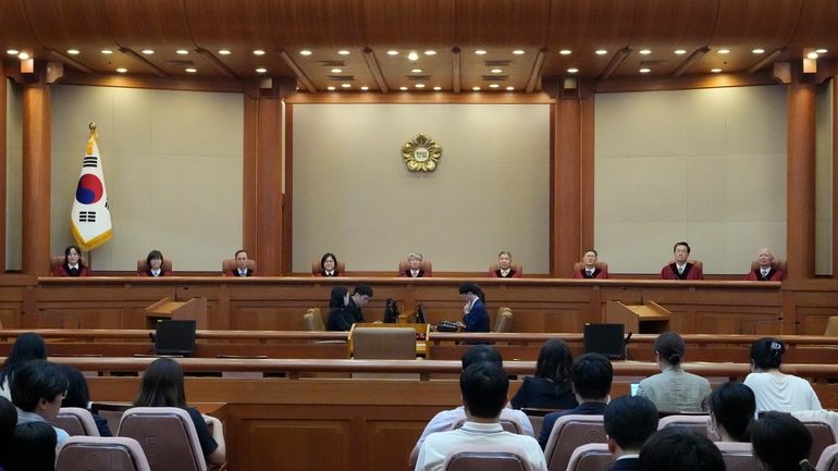 South Korea's Constitutional Court Chief Justice Lee Jong-seok, center, and...