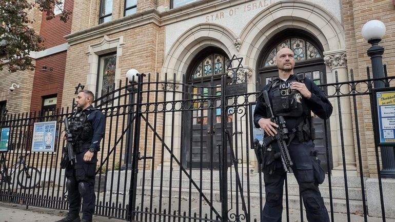 Hoboken Police officers stand watch outside the United Synagogue of...