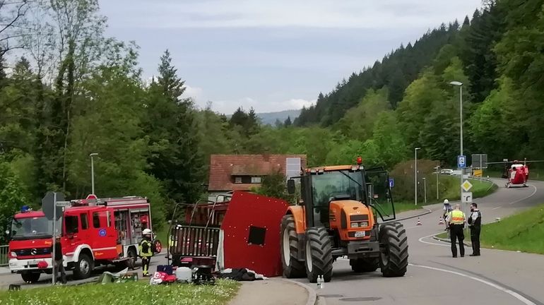 Rescue workers stand next to an overturned May wagon after...