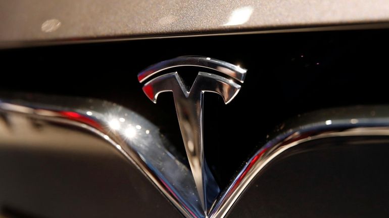 This Oct. 3, 2018, file photo shows a Tesla emblem...