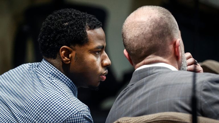 Defendant Justin Johnson, left, appears in court, as the murder...