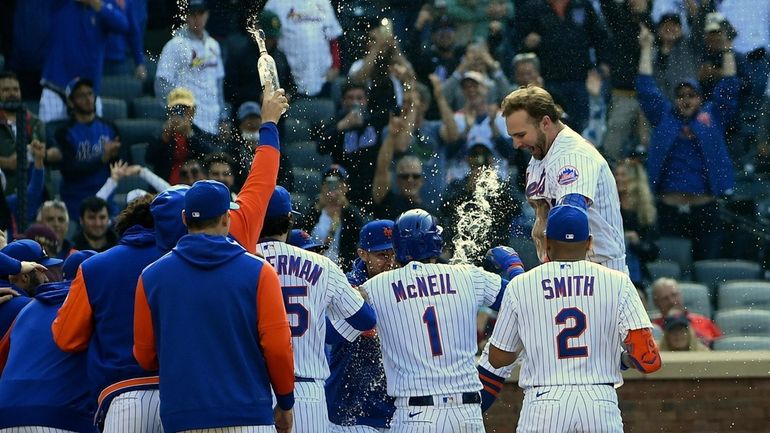 Mets' Pete Alonso is mobbed by teammates at home plate...