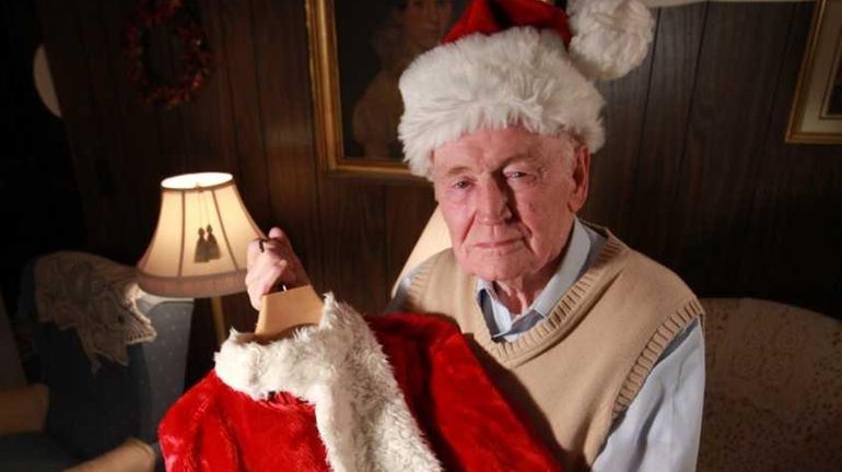 David McKell, 83, of Huntington Station holds up the Santa...