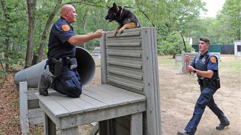 Suffolk County Police Officer Thomas Teufel, left, watches as his...