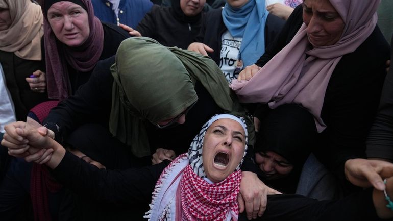 Palestinian Fayrouz Safi cries while she takes the last look...