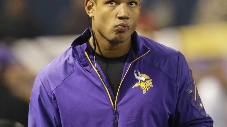 Minnesota Vikings quarterback Josh Freeman watches from the sideline in...