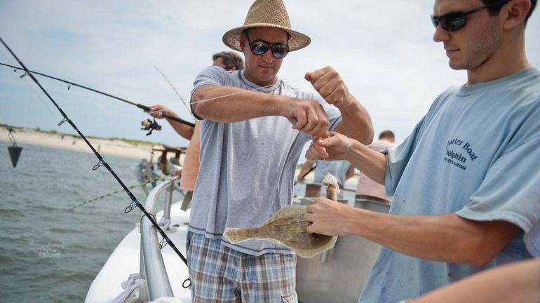 Ed Fitting, of Hicksville, is assisted by Mate Zach Hindin,...