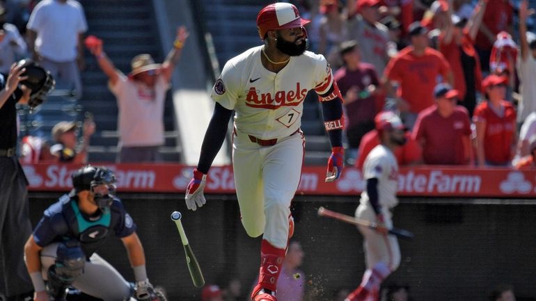 Los Angeles Angels' Jo Adell, right, heads to first for...