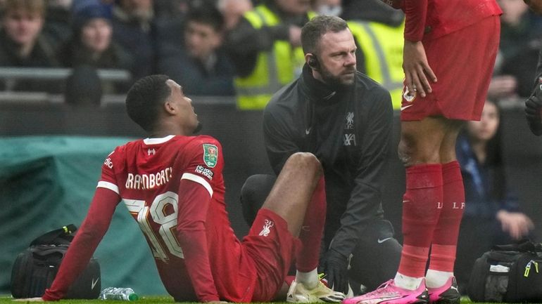 Liverpool's Ryan Gravenberch sits on the pitch after an injury...