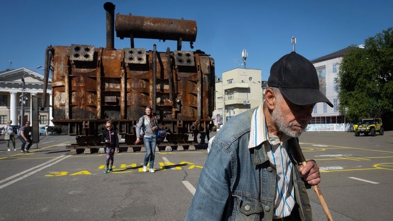 A man passes by a burnt transformer from one of...