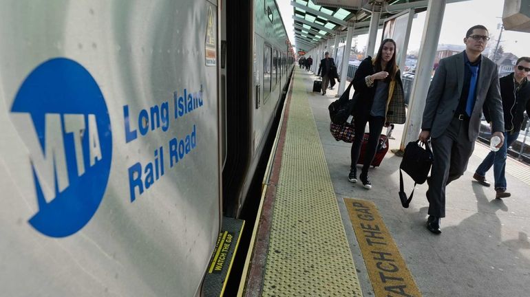 Commuters walk from a Long Island Railroad train after a...