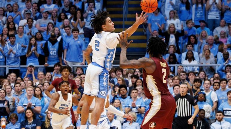 North Carolina's Elliot Cadeau, left, deflects a pass ahead of...