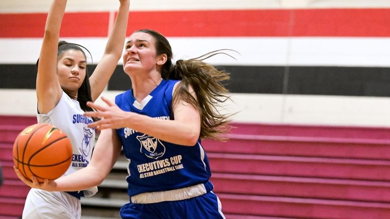 Emily Plachta of Huntington gets around the defense to shoot...