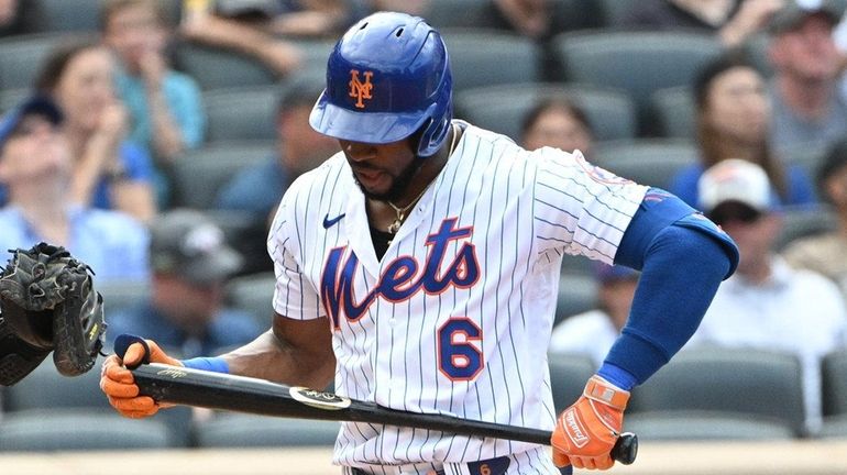 Mets' Starling Marte returns to the dugout after he struck...