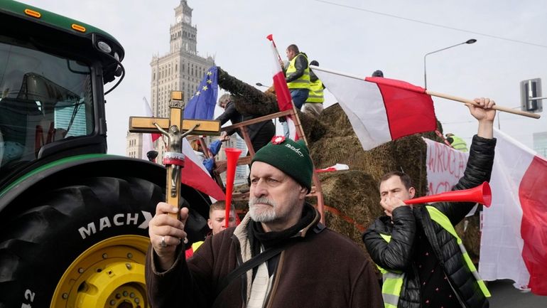 Polish farmers with national flags and angry slogans written on...