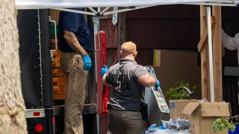 Police remove evidence from the home of Rex A. Heuermann...