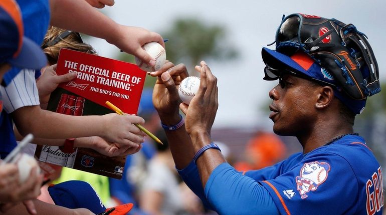 New York Mets rightfielder Curtis Granderson signs autographs before an...