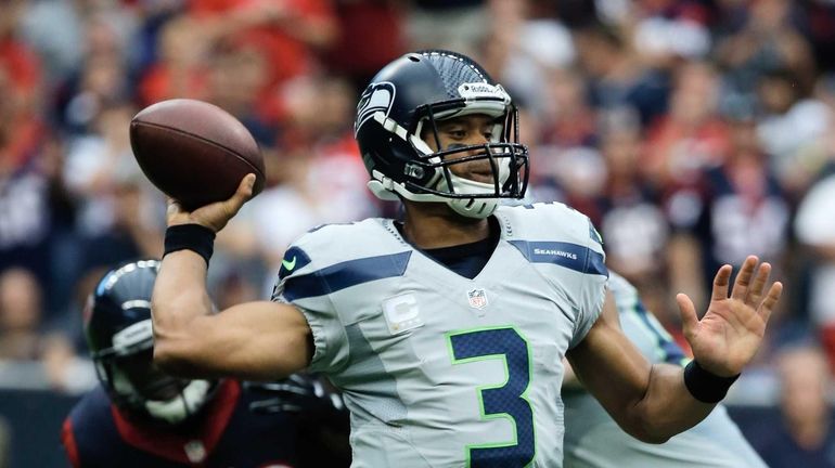 Russell Wilson #3 of the Seattle Seahawks looks to pass...