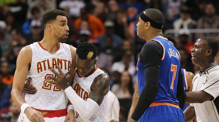 Atlanta Hawks' Dennis Schroder and an official separate the Hawks'...