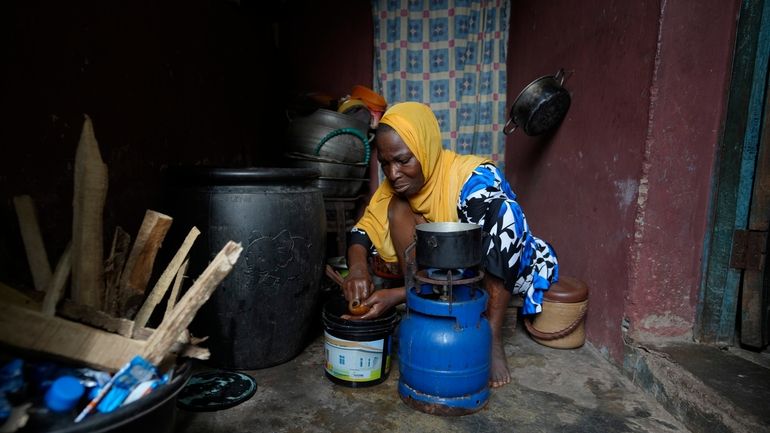 Idowu Bello, 56, prepares a meal in her kitchen in...