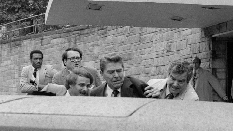 President Ronald Reagan is put into a limo by Secret Service...