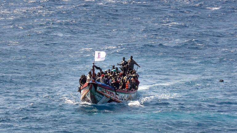 Unauthorized migrants crowd a wooden boat as they sail to...