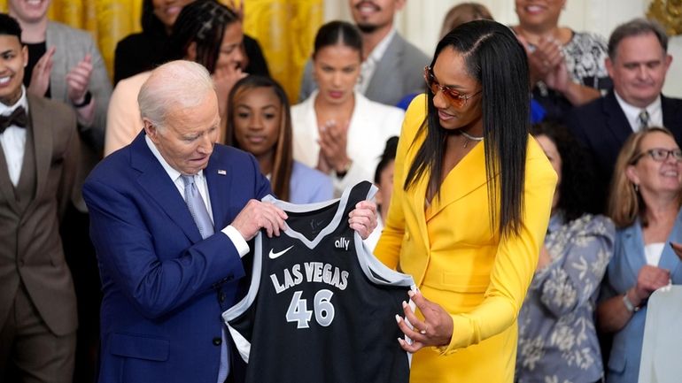 A'ja Wilson, of the WNBA's Las Vegas Aces, right, presents...