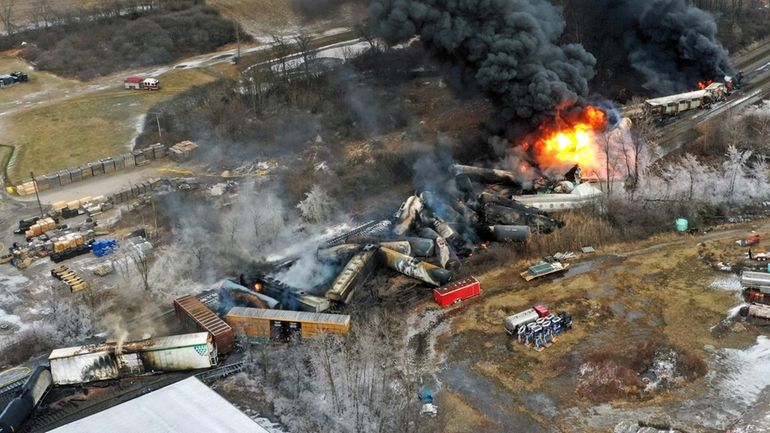 Debris from a Norfolk Southern freight train lies scattered and...