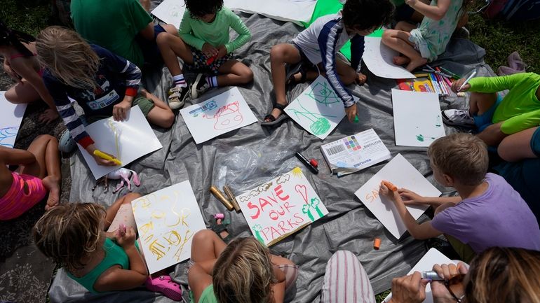 Children make signs as they attend a protest against Gov....