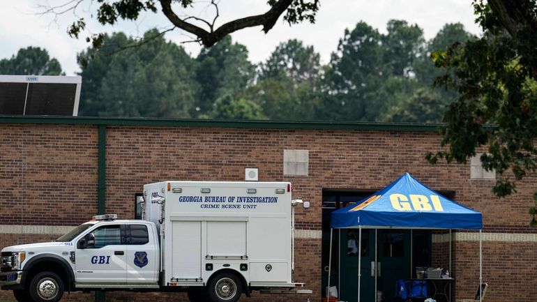 Georgia Bureau of Investigation staff move through an entrance to...