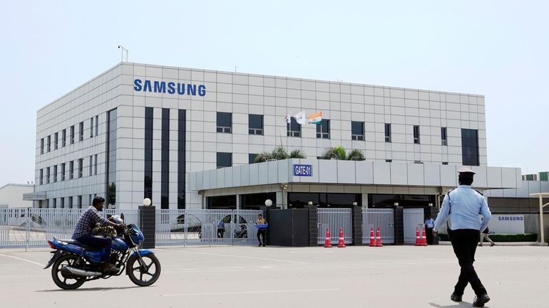 A motorcyclist rides past Samsung company plant in Sriperumbudur, on...