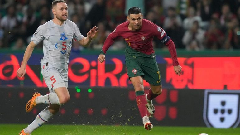 Portugal's Cristiano Ronaldo, right, is challenged by Iceland's Sverrir Ingi...