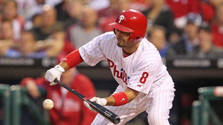 Center fielder Shane Victorino #8 of the Philadelphia Phillies bunts...