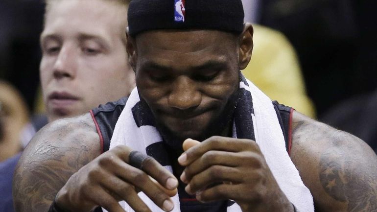 Miami Heat forward LeBron James sits on the bench during...