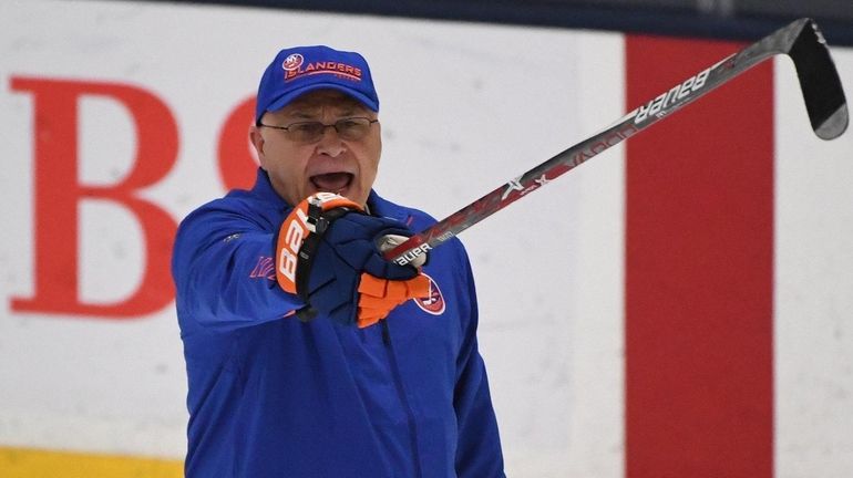 Islanders head coach Barry Trotz directs his players during training...