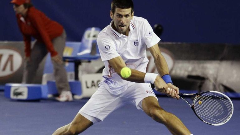 Novak Djokovic hits a backhand return to Andy Murray during...