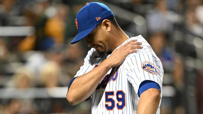 Mets starting pitcher Carlos Carrasco walks to the dugout after...