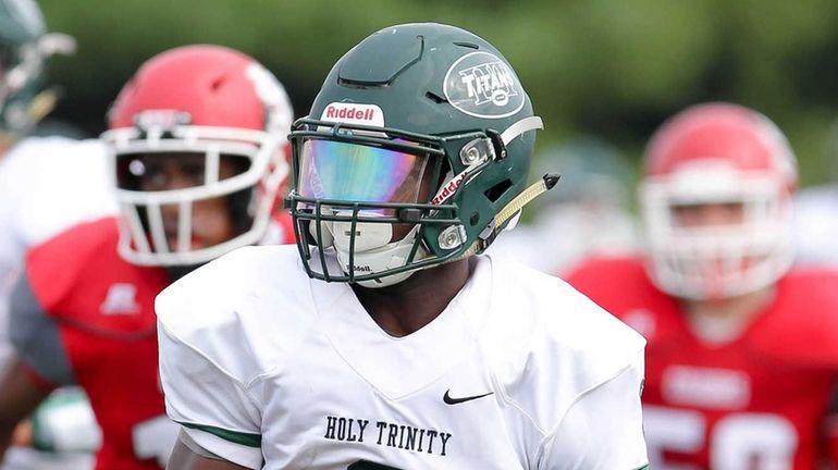 Holy Trinity's Umari Taylor (6) runs a kickoff back for...