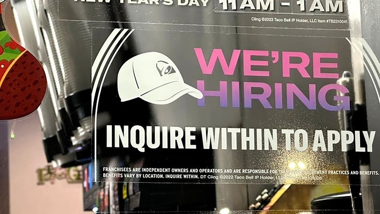 A hiring sign is displayed at a restaurant in Glenview,...