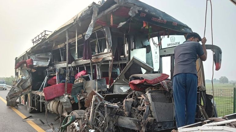 A roadside assistance worker tows away the mangled remains of...