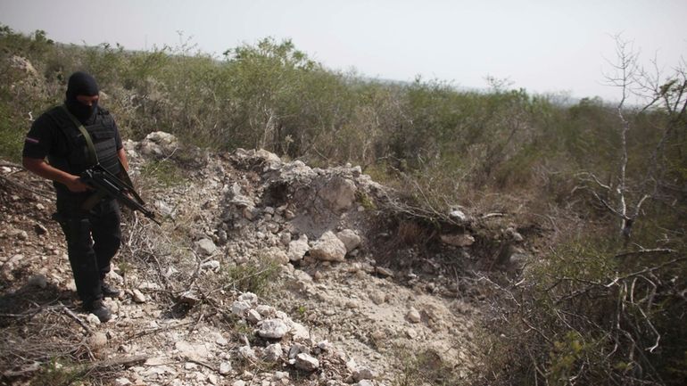 An officer walks past a hole that police say was...