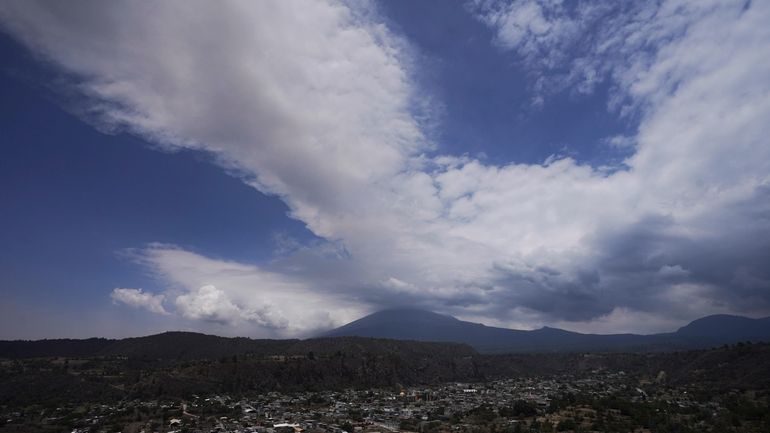 The Popocatepetl volcano spews ash and steam as seen from...