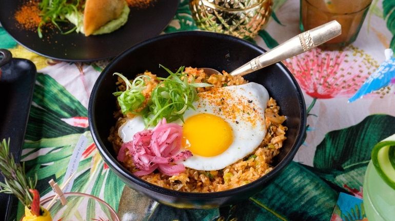 Kimchi fried rice arrives topped with a sunny side egg...