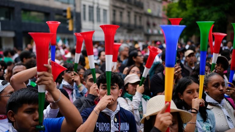 People blows vuvuzelas during a rally in favor of the...