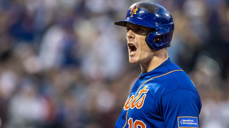 Mets’ Mark Canha reacts after hitting a two-run RBI single...