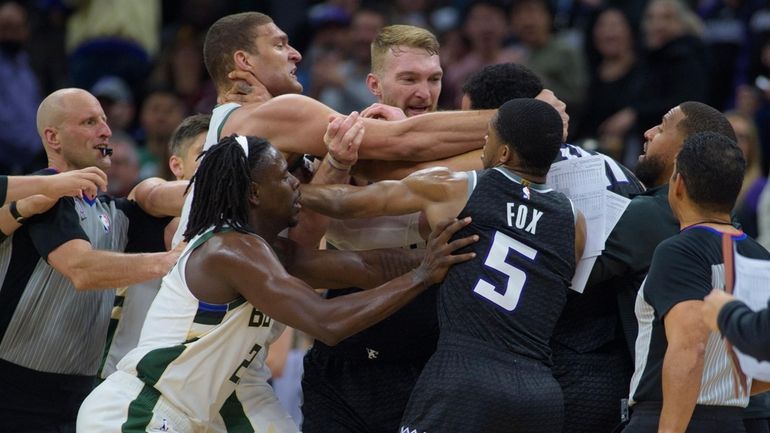 Milwaukee Bucks center Brook Lopez, left scuffles with Sacramento Kings...